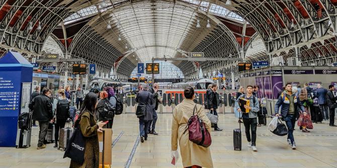Travelers walk through a crowded Paddington Station in London